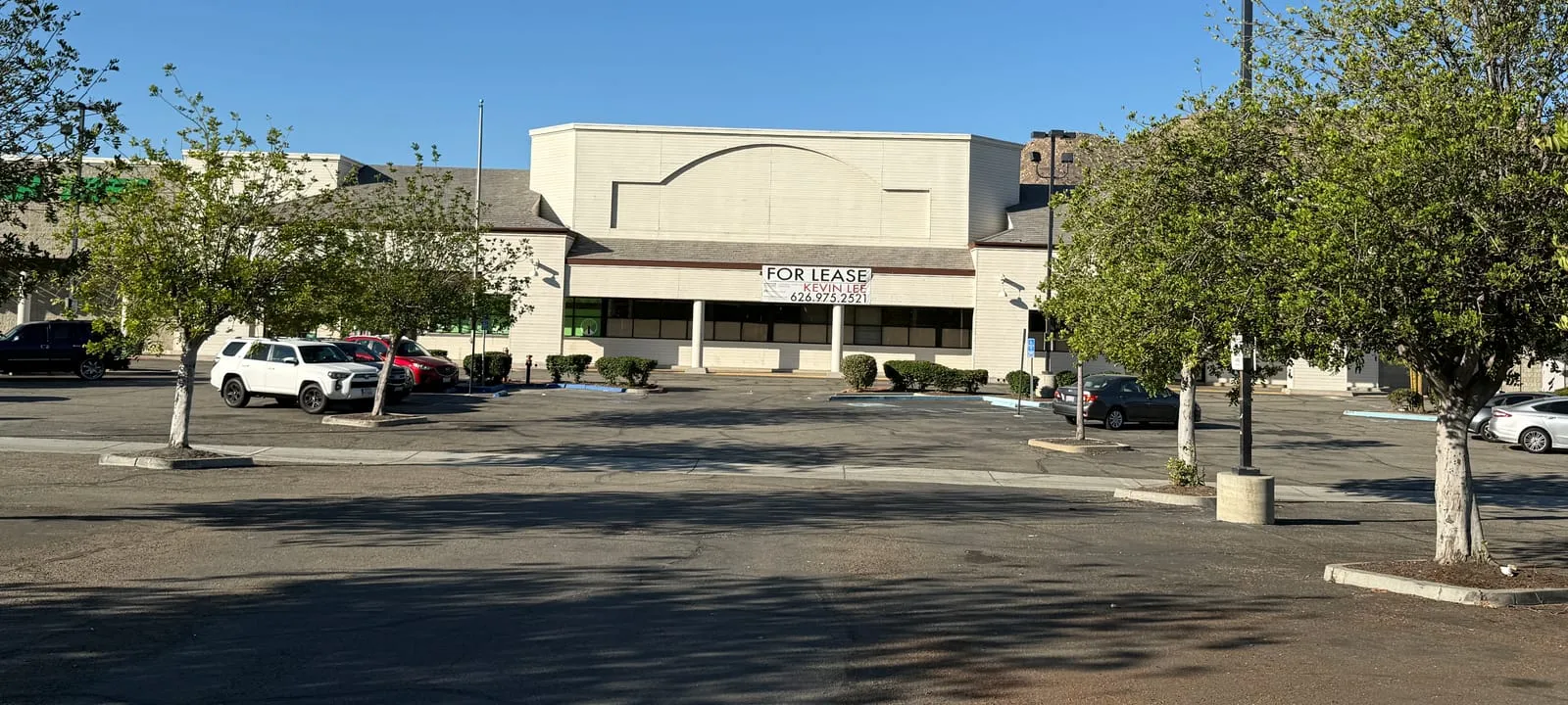 The empty former supermarket at Lakeshore Village, with a For Lease banner over the entrance and a mostly empty parking lot.